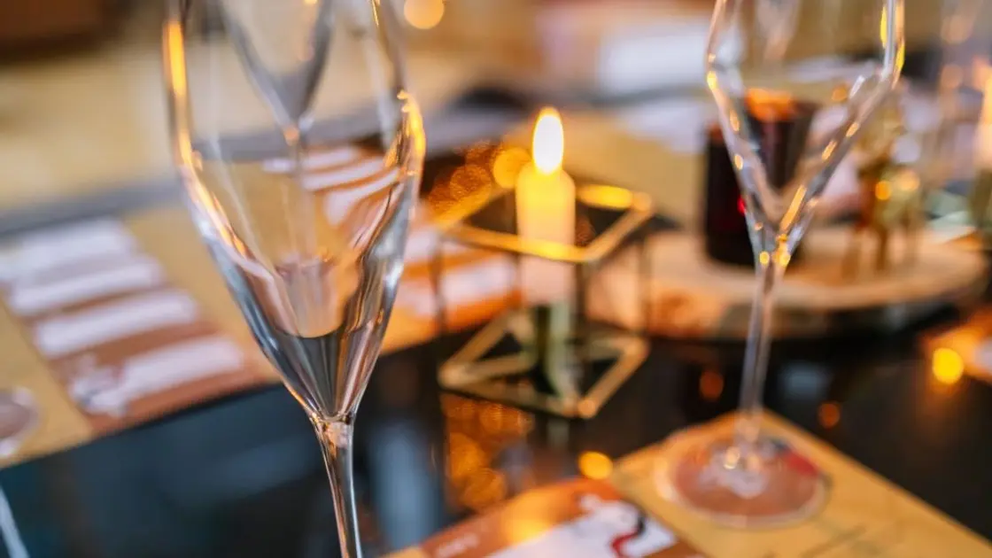 Twee lege champagneglazen op de proefformulieren van het bubbelspel, met kaarslicht op de achtergrond