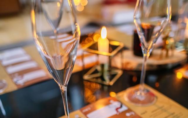 Twee lege champagneglazen op de proefformulieren van het bubbelspel, met kaarslicht op de achtergrond